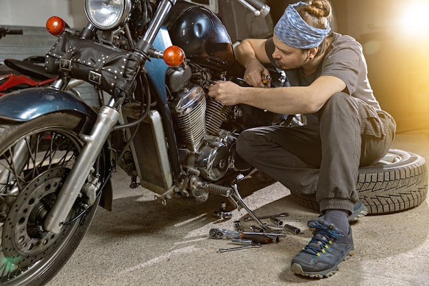 Primer plano de un joven inspeccionando motocicletas antiguas en el taller de reparaciones Esta bicicleta será perfecta