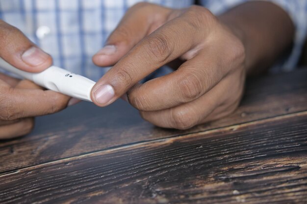 Foto primer plano de un joven midiendo el dedo de un diabético