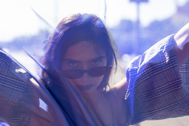 Foto primer plano de una joven a la moda con textiles en la ciudad durante un día soleado