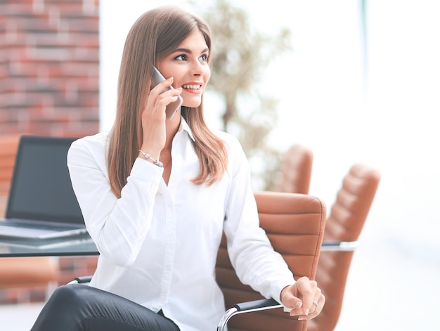 Primer plano de una joven mujer de negocios hablando por un teléfono móvil