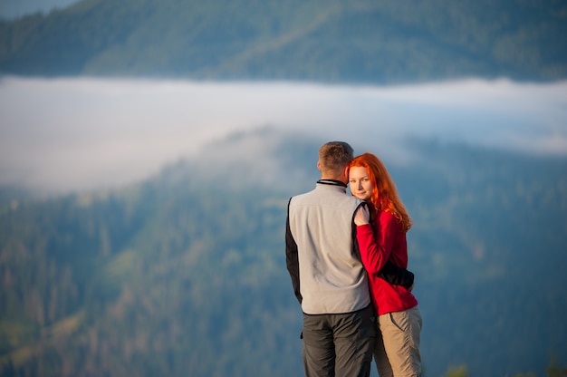 Primer plano de la joven pareja abrazándose y disfrutando de la hermosa montaña