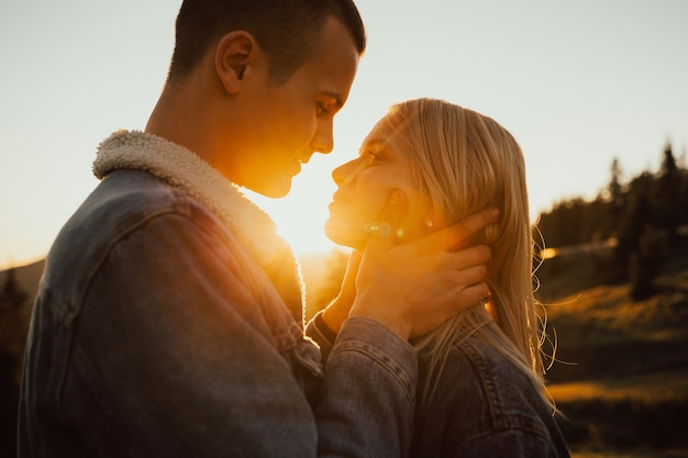 Primer plano de una joven pareja mirándose a la luz del atardecer