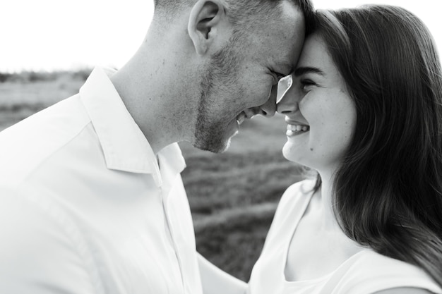 Primer plano de una joven pareja que se encuentra cara a cara con una sonrisa en sus rostros. chico feliz con una chica. retrato de los amantes