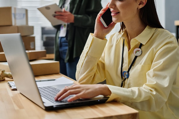 Primer plano de una joven voluntaria que consulta a personas en línea y por teléfono