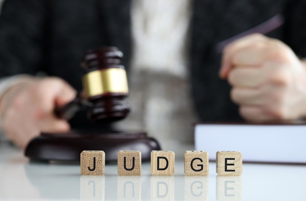 Primer plano del juez mundial recogido de cubos de madera letras justicia y derecho juez masculino en