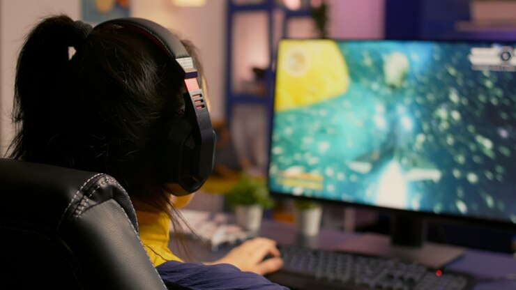 Foto primer plano del jugador sentado en una silla de juego y jugando al videojuego en línea del tirador espacial para el torneo virtual. hombre jugador con auriculares de transmisión de juegos en una habitación con luz de neón y equipos modernos