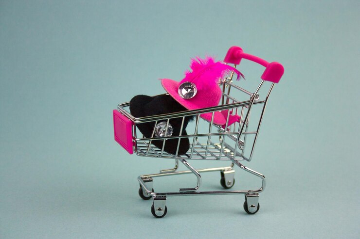 Foto primer plano de juguetes en un pequeño carrito de compras contra un fondo de colores