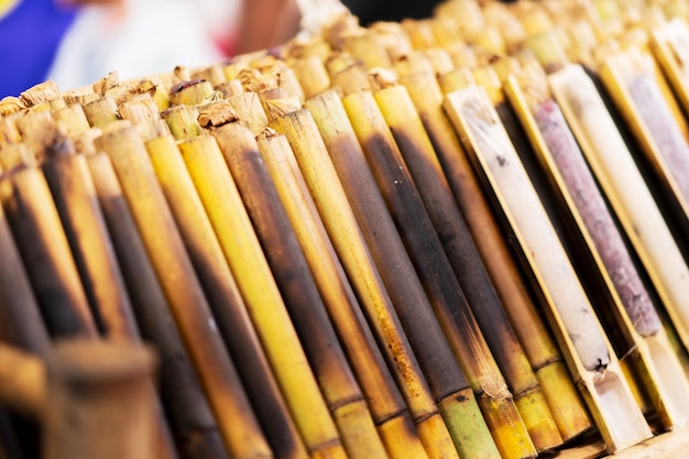 Primer plano de Khao Lam, arroz glutinoso horneado en un cilindro de bambú, mercado de comida callejera tailandesa