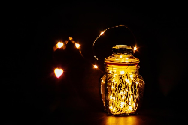 Foto primer plano de la lámpara iluminada en la mesa contra un fondo negro