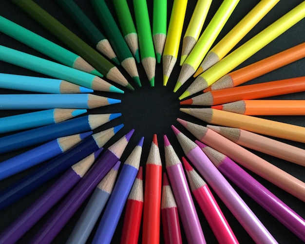 Primer plano de lápices de colores dispuestos contra un fondo negro