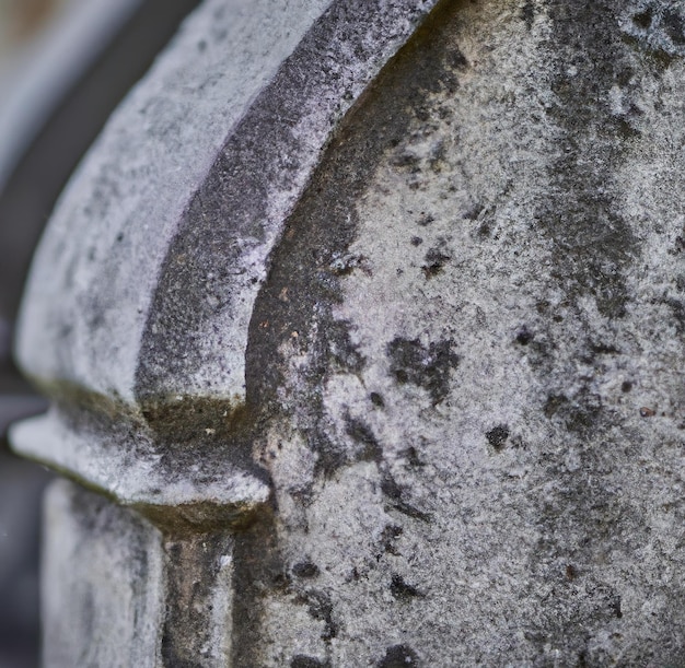 Primer plano de una lápida gris en el cementerio sobre un fondo borroso