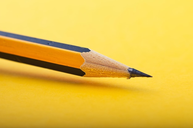 Primer plano de lápiz amarillo sobre fondo amarillo
