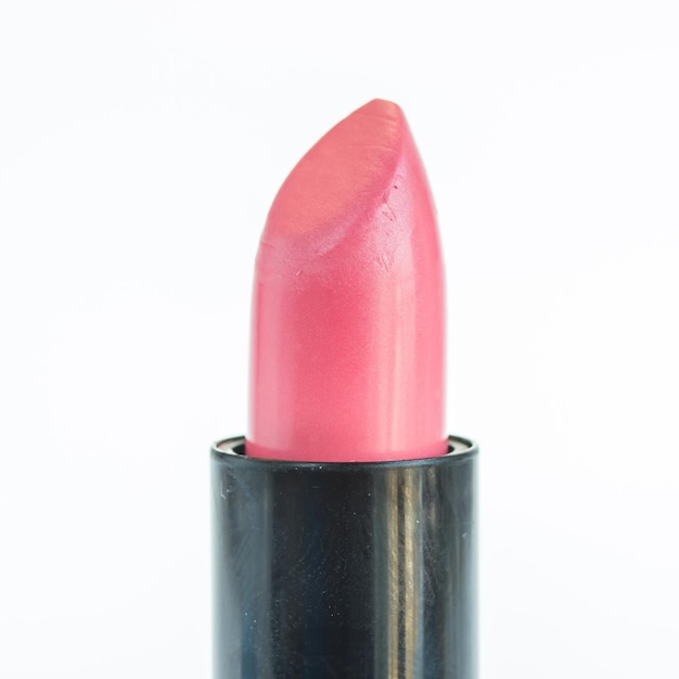 Primer plano de lápiz labial rosado contra un fondo blanco