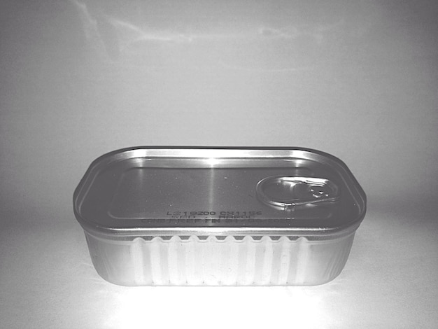 Primer plano de una lata de sardina sobre un fondo gris