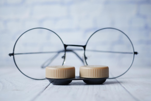 Foto primer plano de lentes de contacto y anteojos en la mesa