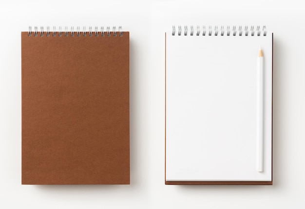 Primer plano de la libreta y el lápiz de color contra un fondo blanco