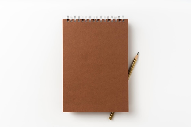 Primer plano de la libreta y el lápiz contra un fondo blanco