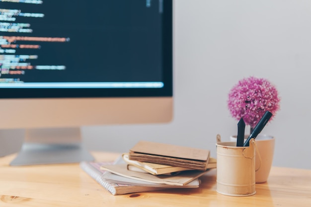 Primer plano de libros por computadora de escritorio en una mesa de madera