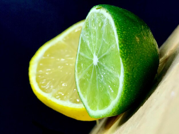 Primer plano de un limón verde contra un fondo negro
