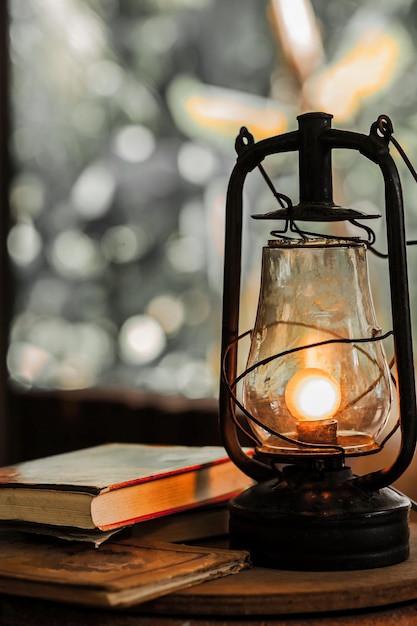 Primer plano de una linterna iluminada por los libros en la mesa