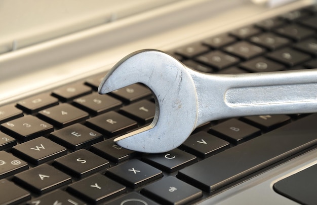 Primer plano de una llave inglesa en el teclado de la computadora