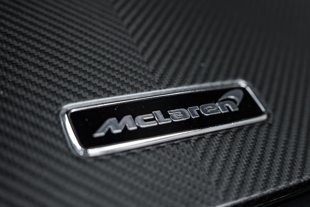 Un primer plano del logotipo de McLaren en un fondo de fibra de carbono