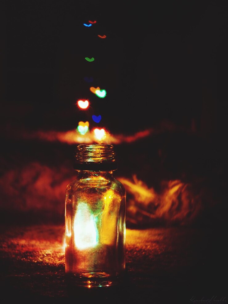 Foto primer plano de luces coloridas en forma de corazón sobre una botella de vidrio