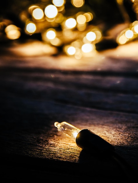 Foto primer plano de luces de cuerda iluminadas en una mesa de madera