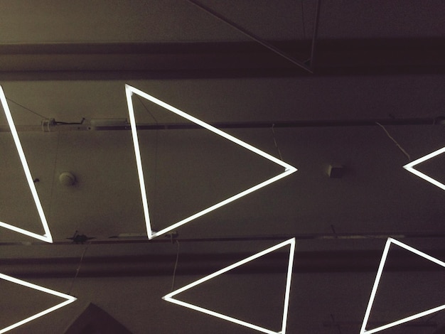 Primer plano de las luces de neón triangulares en la pared