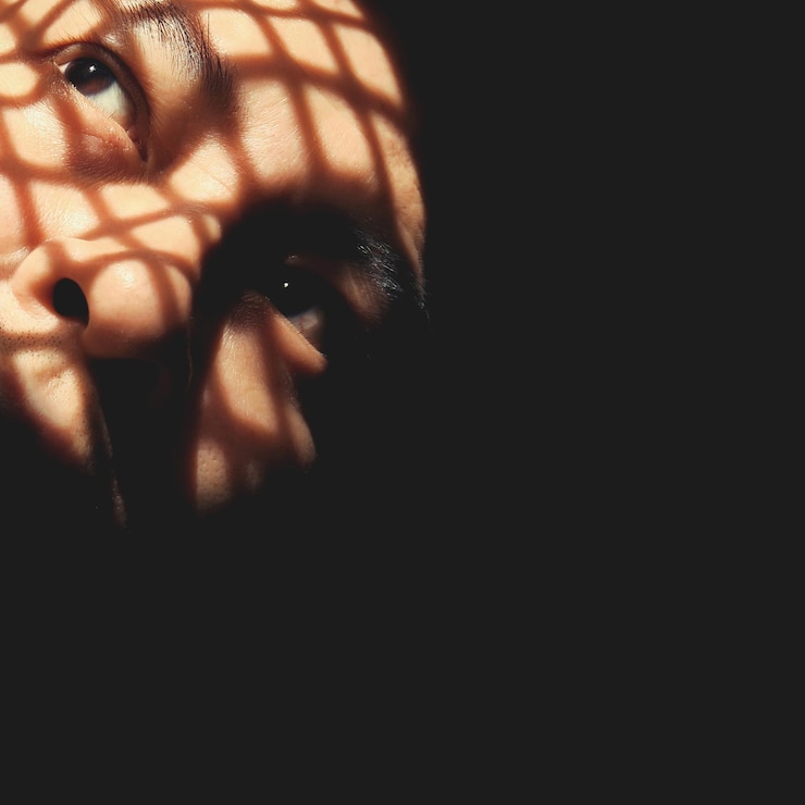 Foto primer plano de la luz del sol en la cara del hombre en el cuarto oscuro