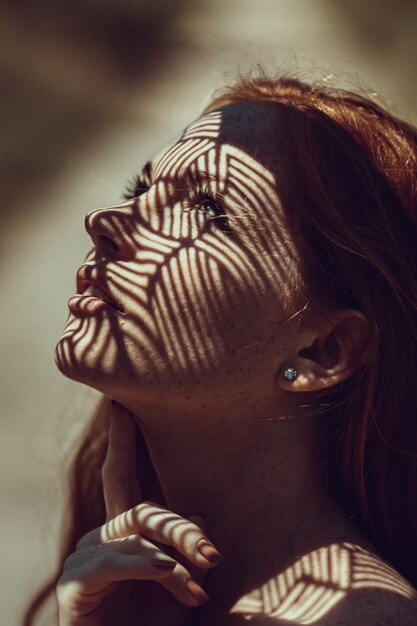 Foto primer plano de la luz del sol y la sombra en el rostro de una hermosa mujer