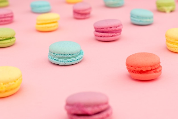 Primer plano de macarrones multicolores contra un fondo rosado