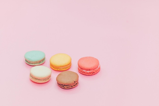 Primer plano de macarrones multicolores sobre un fondo rosado