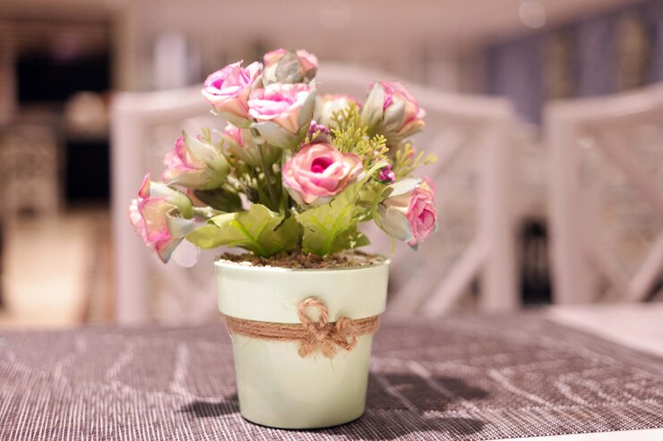 Foto primer plano de una maceta de flores rosadas en la mesa