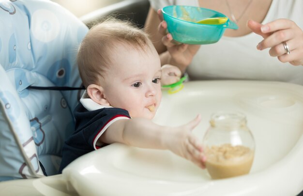 Primer plano de una madre alimentando a un bebé con gachas de avena