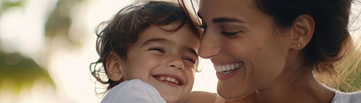 Un primer plano de una madre y un hijo sonrientes compartiendo un momento de alegría juntos mostrando amor y felicidad en un entorno natural sus expresiones irradian calor y conexión