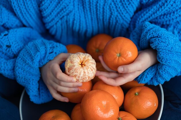 Primer plano de una mandarina en manos de un niño