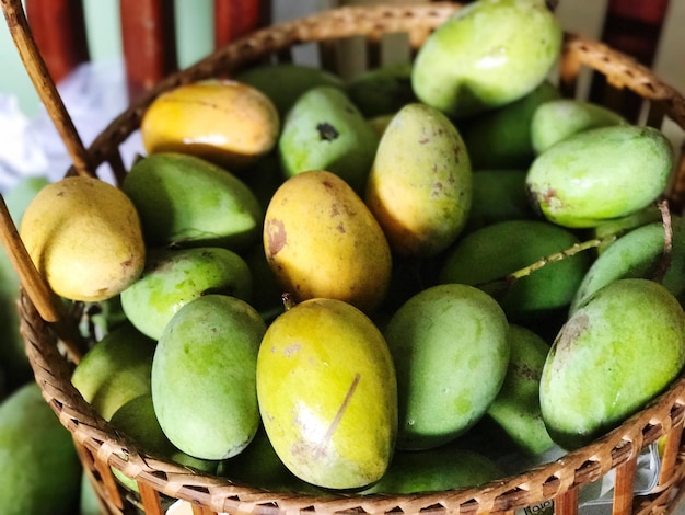 Primer plano de mangos en una canasta de mimbre