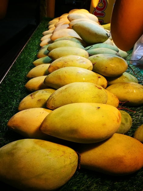 Foto primer plano de mangos para la venta en el mercado por la noche.