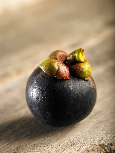 Foto primer plano de un mangostán en una mesa de madera