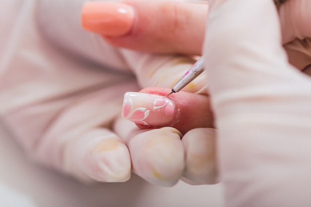 Foto primer plano de una manicurista trabajando en uñas