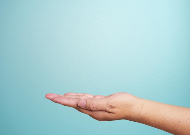 Primer plano de la mano aislado sobre fondo azul Palma hacia arriba