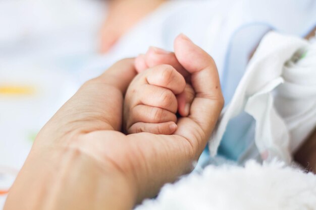 Foto primer plano de la mano del bebé en la cama