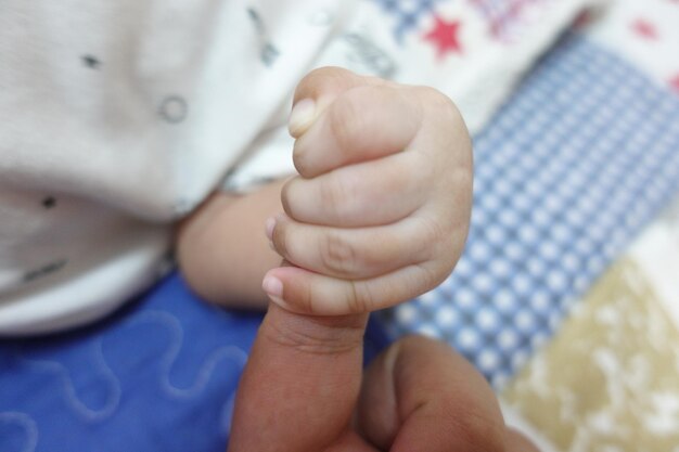 Foto primer plano de la mano del bebé en la cama