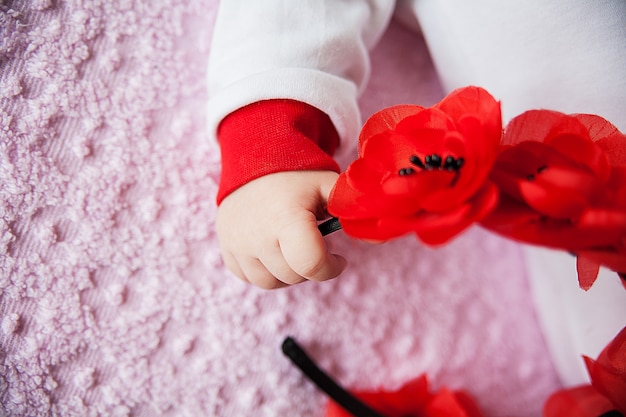 Primer plano de la mano del bebé recién nacido con flores