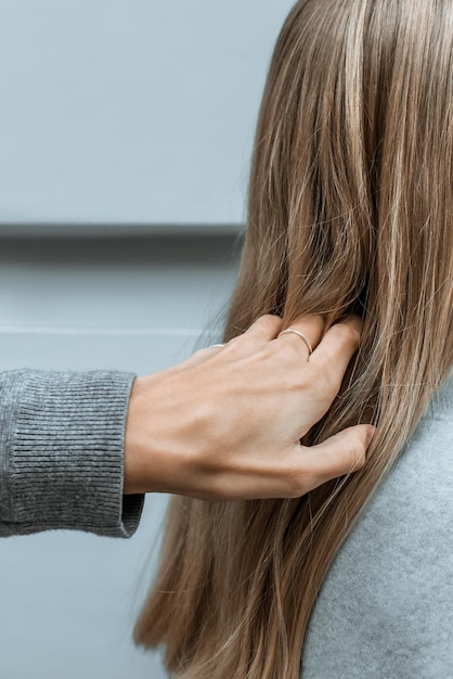 Primer plano de una mano en el cabello de una mujer