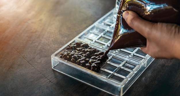 Primer plano de mano chef haciendo barras de chocolate caseras