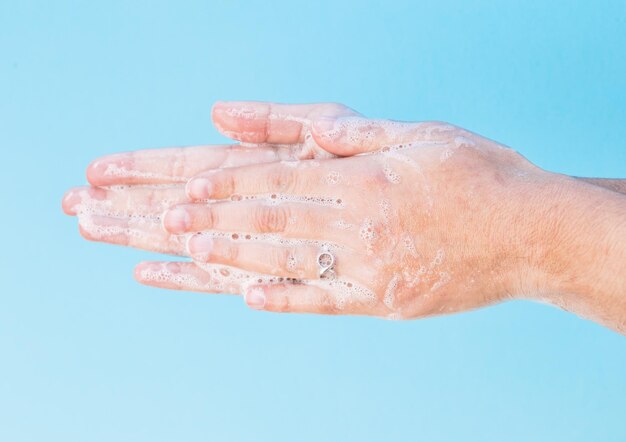 Foto primer plano de la mano contra un fondo azul