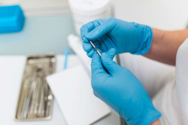 Foto primer plano de la mano de un dentista con herramienta dental