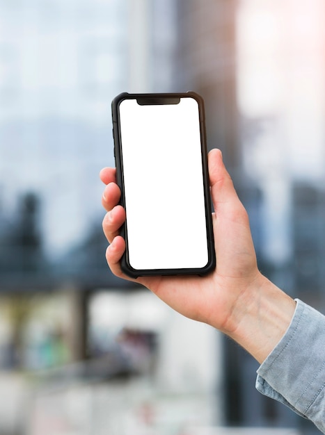 Foto primer plano de la mano del empresario sosteniendo un teléfono móvil con pantalla blanca